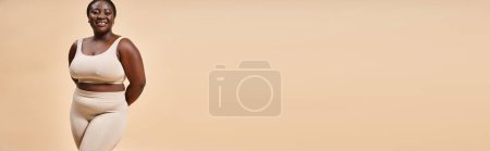 Téléchargez les photos : Bannière de femme heureuse plus taille en sous-vêtements beige posant en studio, corps positif et estime de soi - en image libre de droit