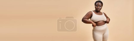 confident plus size woman in underwear posing on beige backdrop, body positive banner