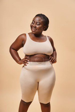 Photo for Happy plus size woman in underwear posing with hands on hips, body positive and female empowerment - Royalty Free Image