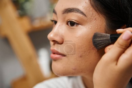 primer plano de la joven mujer asiática con acné piel propensa a aplicar polvo facial, problemas de piel y maquillaje