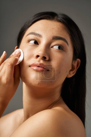 jeune femme asiatique avec des cheveux bruns et l'acné peau sujette à regarder miroir dans la salle de bain, bannière