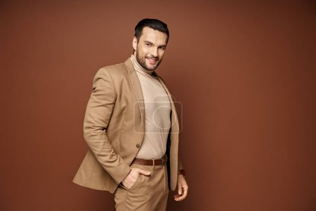 Téléchargez les photos : Homme gai avec soies posant dans un élégant blazer beige avec la main dans la poche sur fond beige - en image libre de droit