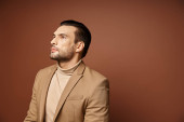 handsome man in elegant attire looking away while thinking on beige background, ideas generating Poster #692773936