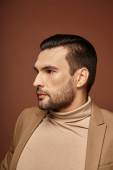 handsome man in elegant attire looking away on beige background, fashion-forward businessman mug #692774084
