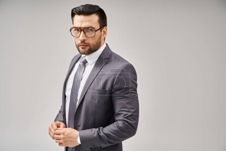 Photo for Handsome businessman in formal wear and glasses standing on grey background, elegance and style - Royalty Free Image