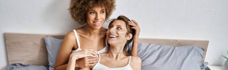 happy african american woman with curly hair having great time with girlfriend in morning, banner