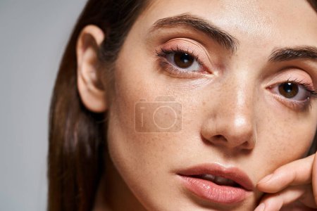 Photo for A close-up of a young Caucasian woman with mesmerizing brown eyes and clean skin in a studio setting. - Royalty Free Image