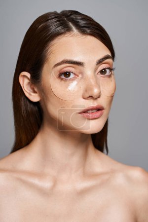 Téléchargez les photos : Une jeune femme caucasienne aux cheveux bruns et à la peau propre, présentant un patch sur sa joue. - en image libre de droit