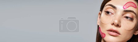 Téléchargez les photos : Jeune femme caucasienne aux cheveux bruns a des taches hydratantes roses vibrantes sur son visage, bannière - en image libre de droit