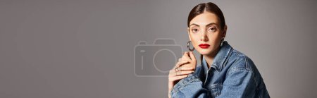 Photo for A young woman with brunette hair in a stylish jean jacket and bold red lipstick, banner - Royalty Free Image