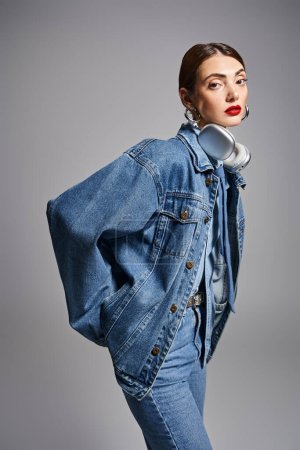 A stylish young Caucasian woman with brunette hair wearing a denim jacket and jeans, exuding confidence and attitude.