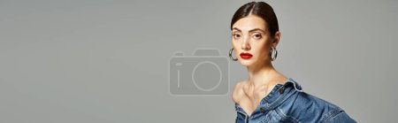 A young Caucasian woman with brunette hair and clean skin confidently wears a denim shirt and red lipstick, banner