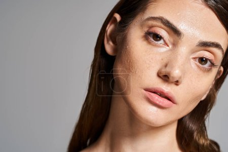 Téléchargez les photos : Une jeune femme caucasienne aux longs cheveux bruns regarde mystérieusement avec ses yeux bruns captivants dans un cadre de studio. - en image libre de droit