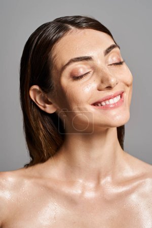 Eine junge kaukasische Frau mit brünetten Haaren und geschlossenen Augen lächelt im Studio