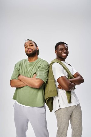 Téléchargez les photos : Juneteenth concept, deux amis afro-américains masculins debout avec les bras croisés sur fond gris - en image libre de droit