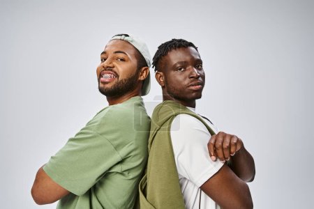 Juneteenth, Porträt afrikanisch-amerikanischer Freunde mit verschränkten Armen auf grauem Hintergrund