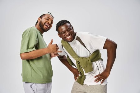 Téléchargez les photos : Heureux juincélébration, excité et jeunes amis afro-américains étreignant sur fond gris - en image libre de droit