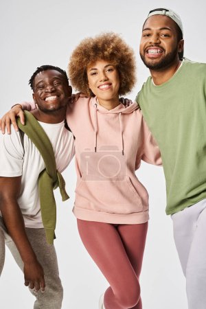 optimistic african american men and woman standing on grey background, Juneteenth celebration