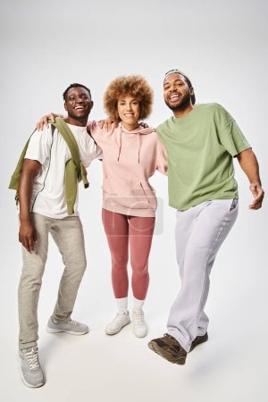 joyeux jeunes hommes et femmes afro-américains debout sur fond gris, Célébration du 10 juin