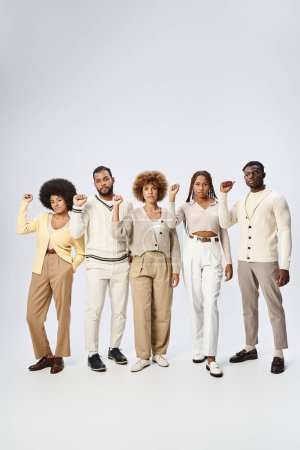 Téléchargez les photos : Juneteenth concept, heureux peuple afro-américain debout avec les poings serrés sur fond gris - en image libre de droit