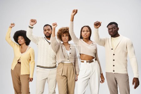Téléchargez les photos : Le 10 juin et l'activisme, heureux peuple afro-américain avec les poings serrés sur fond gris - en image libre de droit