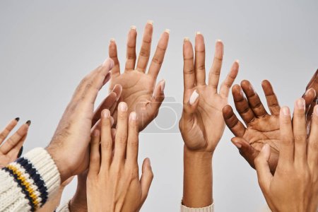 abgeschnittene Ansicht afrikanisch-amerikanischer Menschen, die die Hände vor grauem Hintergrund ausstrecken, Konzept vom Juni