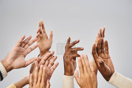 Ausgeschnittene Ansicht einer afrikanisch-amerikanischen Gemeinschaft, die die Hände vor grauem Hintergrund ausstreckt, Juni