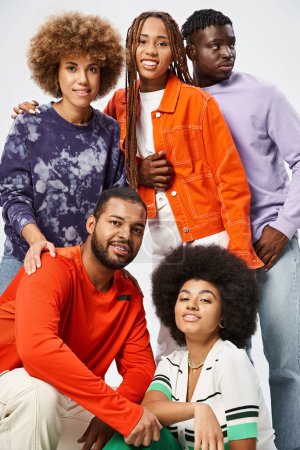 happy african american friends in casual wear spending time together on grey background, Juneteenth
