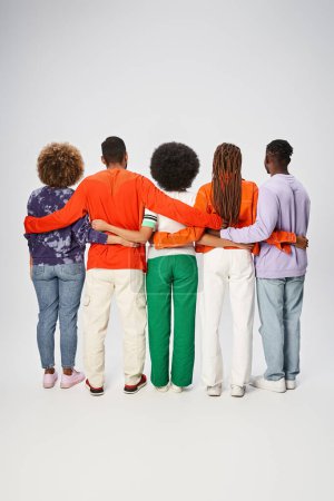 back view of african american people in casual attire hugging on grey backdrop, Juneteenth