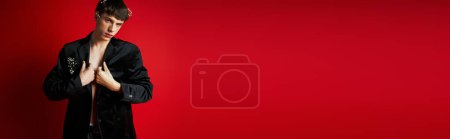 Photo for Banner of young man in velvet blazer with flowers in hair looking at camera on red backdrop - Royalty Free Image