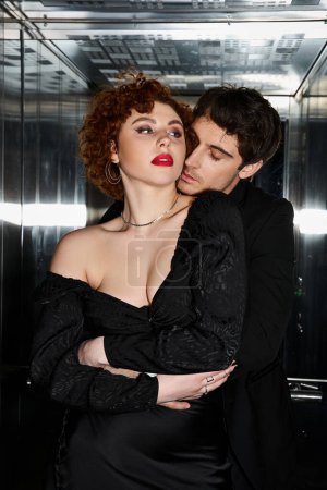 sexy atractiva pareja en elegante vestido negro y traje abrazándose amorosamente en ascensor después de la fecha