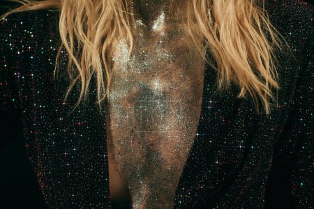 cropped shot of woman with sparkling glitter on chest and jacket with sequins on black background