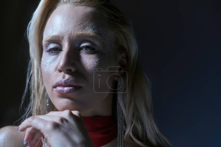Porträt einer schönen Frau mit Textmarker und grünen Augen, die vor dunklem Hintergrund in die Kamera blickt