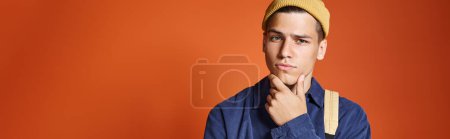 Photo for Banner of young man in yellow hat thinking about idea against terracotta background - Royalty Free Image