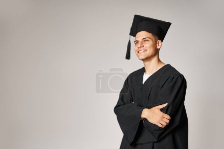 Photo for Portrait of attractive student in graduate gown and cap smiling and looking forward - Royalty Free Image