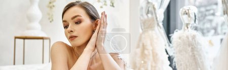 Photo for A young brunette bride, dressed in a white gown, delicately holds her hands up to her face in a moment of quiet reflection. - Royalty Free Image