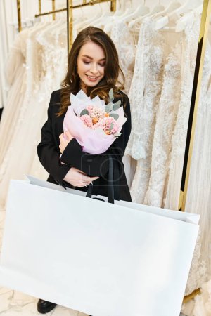 A young brunette bride delicately holds a vibrant bouquet of flowers in her hands, radiating joy and elegance.