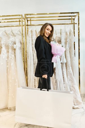 A young brunette bride browsing through a rack of dresses in a wedding salon.