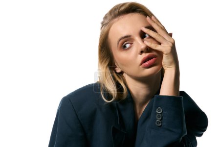 Photo for Appealing woman with blonde hair in chic blue blazer posing on white background and looking away - Royalty Free Image