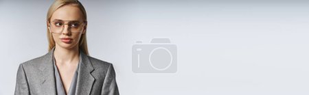 Photo for Fashionable good looking businesswoman in sophisticated suit with blonde hair looking away, banner - Royalty Free Image