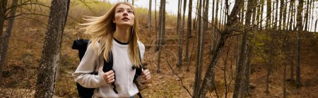 Mujer joven con mochila caminando en el bosque senderismo e ir de camping en la naturaleza, pancarta