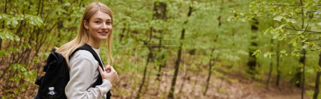 Foto de Volver ver retrato de sonriente rubia viajero senderismo en el bosque y el uso de la mochila, pancarta - Imagen libre de derechos