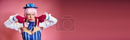 Photo for Young sexy woman with red gloves and blue hat showing crying gesture on pink backdrop, banner - Royalty Free Image