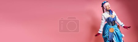 Téléchargez les photos : Sexy cosplayer féminin en chapeau bleu et tenue vibrante en regardant la caméra sur fond rose, bannière - en image libre de droit