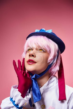 attraktive modische Frau Cosplay niedlichen Anime-Charakter und wegschauen auf rosa Hintergrund