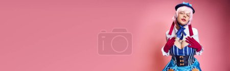 Photo for Alluring female cosplayer in blue hat and vivid dress looking at camera on pink backdrop, banner - Royalty Free Image