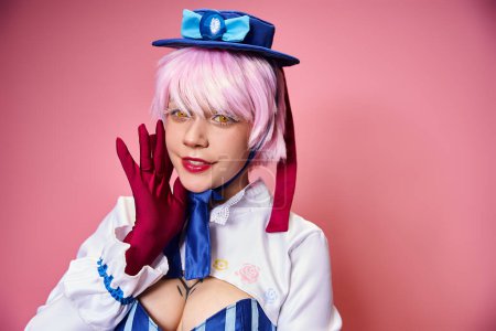 appealing chic female cosplayer in blue stylish hat looking at camera with her hands near face