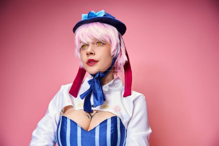 alluring fashionable woman cosplaying cute anime character and looking away on pink backdrop
