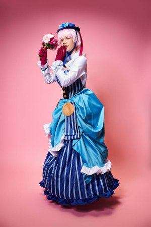 Téléchargez les photos : Attractive cute female cosplayer in vibrant costume holding pink flowers and looking at camera - en image libre de droit
