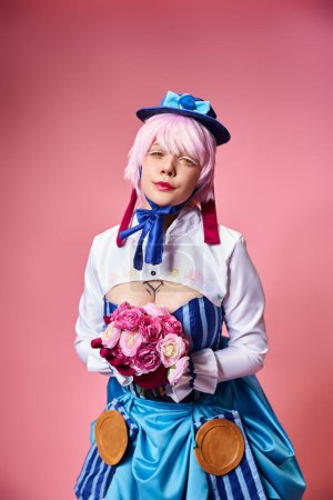 alluring cute female cosplayer in vibrant costume holding pink flowers and looking at camera